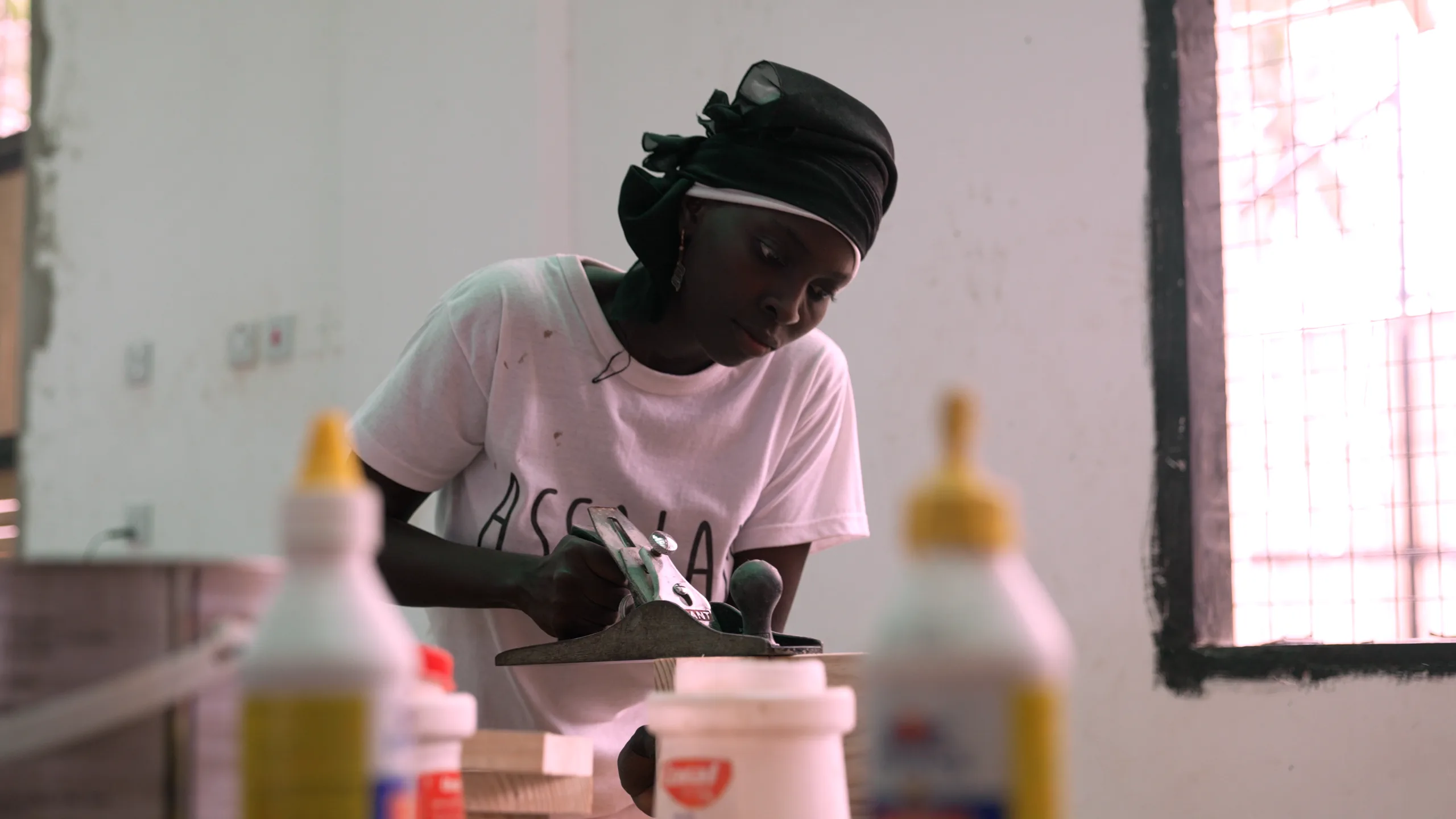 A woman developing practical woodworking skills at Assalam