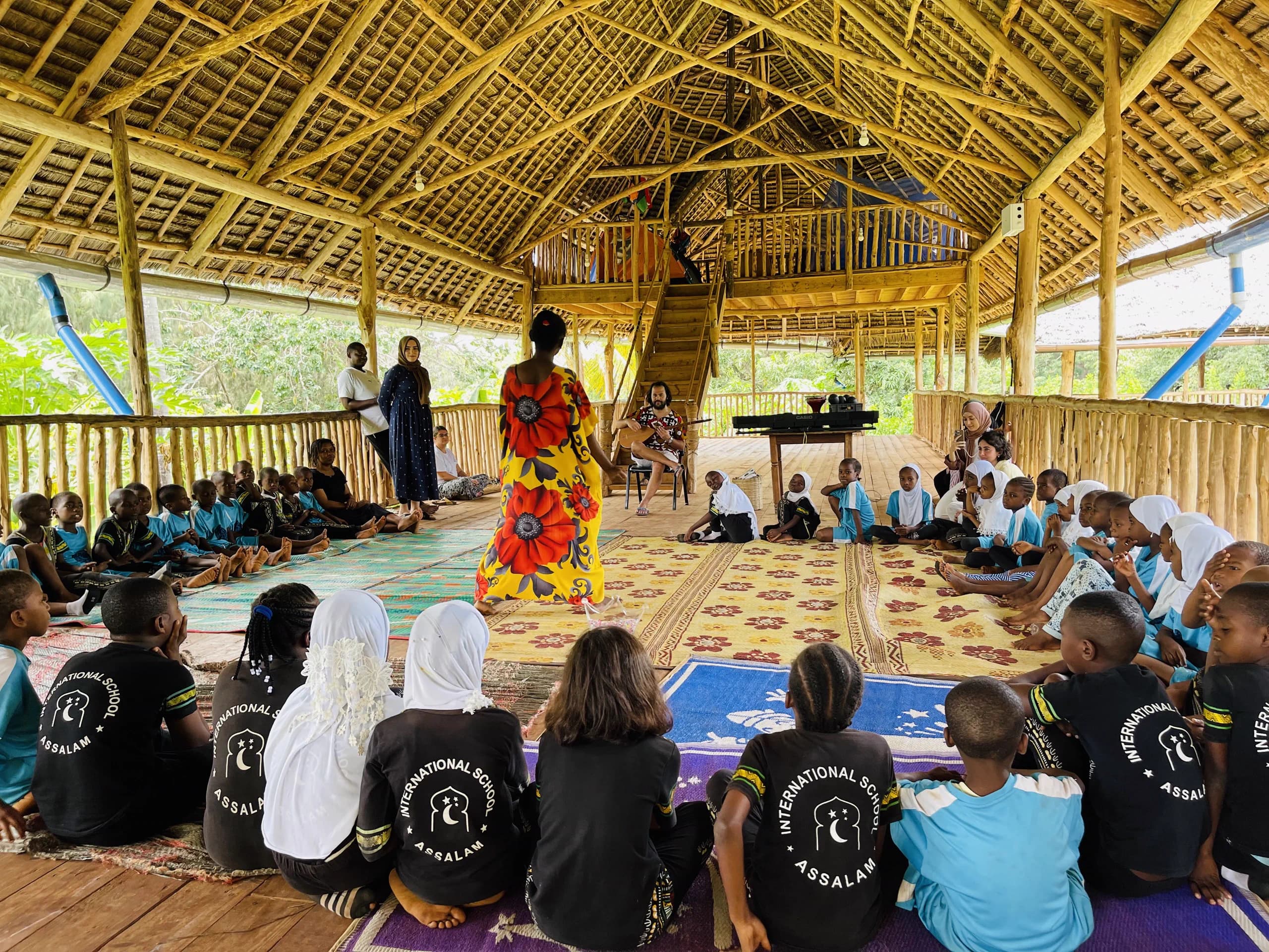 Students and facilitators learning together beneath a Makuti pavilion